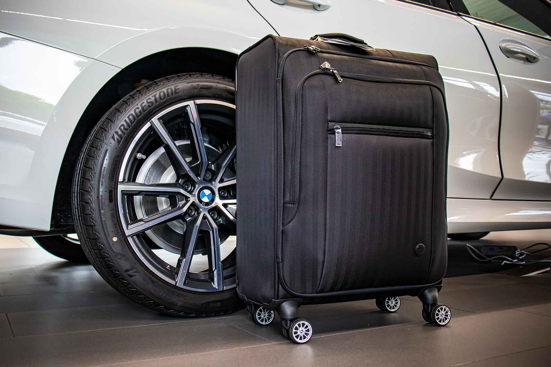 Koffer von BMW Collection neben BMW Fahrzeug